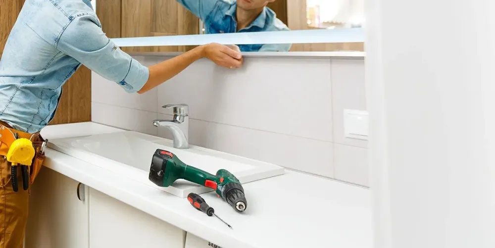 Artisan-qui-installe-un-miroir-dans-une-salle-de-bain-1920w